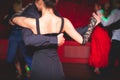 Couples dancing traditional latin argentinian dance milonga in the ballroom, tango salsa bachata kizomba lesson in the red lights Royalty Free Stock Photo