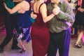 Couples dancing traditional latin argentinian dance milonga in the ballroom, tango salsa bachata kizomba lesson in the red and Royalty Free Stock Photo