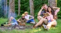 Couples or families having great time relaxing near campfire. Couples spend time outdoors on sunny day. Pleasant weekend Royalty Free Stock Photo