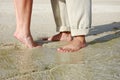 Couples feet standing on beach