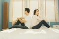 Couples, girlfriends, quarreling with husbands, dissatisfied with each other, sitting on the bed, not looking at each other. Royalty Free Stock Photo