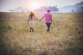 Couples holding hand walking in ranch field and sun light background