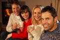 Couples Sitting On Sofa With Hot Drinks Talking Royalty Free Stock Photo