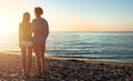Couples during a sunrise at the beach Royalty Free Stock Photo
