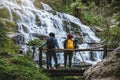 Couples travel relax to photograph the waterfalls beautiful. In the winter. at the waterfall mae ya chiangmai in thailand. travel