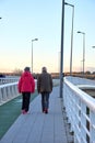Couples walking on the bridge at sunset. Daily exercise, healthy living