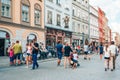 Couples and young families with children walking on busy street in old town Krakow.