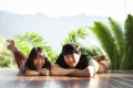 Couples of younger asian man and woman lying with happiness face on home wood floor