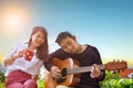 Couples of younger asian man and woman relaxing playing guitar i