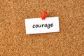 Courage. Word written on a piece of paper, cork board background Royalty Free Stock Photo