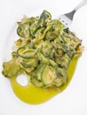 Courgettes with fork on white dish.