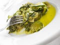 Courgettes with olive oil on white dish.