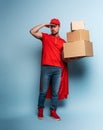 Courier acts like a powerful superhero. Concept of success and guarantee on shipment. Studio cyan background