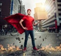 Courier acts like a powerful superhero in a city with skyscrapers. Concept of success and guarantee on shipment Royalty Free Stock Photo