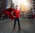 Courier acts like a powerful superhero in a city with skyscrapers. Concept of success and guarantee on shipment Royalty Free Stock Photo