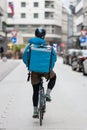 Courier On Bicycle Delivering Food In City.