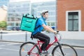 Courier On Bicycle Delivering Food In City