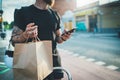 Courier bicycle delivery food service at home.Bearded Man courier using a map app on mobile phone to find the delivery