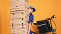 Courier burdened by huge pile of pizza