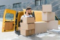 Courier carrying cardboard boxes from delivery van Royalty Free Stock Photo