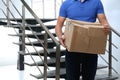 Courier with damaged cardboard box indoors. Poor quality delivery service Royalty Free Stock Photo