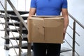 Courier with damaged cardboard box indoors. Poor quality delivery service Royalty Free Stock Photo