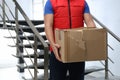 Courier with damaged cardboard box indoors. Poor quality delivery service Royalty Free Stock Photo