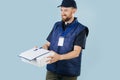 Courier delivering box, offering to sign a paper form, that lies on top of box. Royalty Free Stock Photo