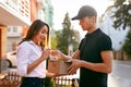 Courier Delivering Package To Woman, Client Signing Document Royalty Free Stock Photo