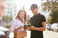 Courier Delivering Package To Woman, Client Signing Document Royalty Free Stock Photo