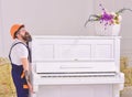 Courier delivers furniture, move out, relocation. Man with beard worker in helmet and overalls lifts up, efforts to move Royalty Free Stock Photo