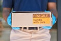 Courier, delivery and box with label for fragile goods, handle with care and shipping closeup, safety and protection