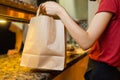 Courier delivery food service at home. Woman courier delivered the order no name bag with food.