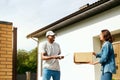 Courier Delivery. Man Delivering Package To Woman At Home Royalty Free Stock Photo