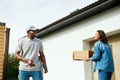 Courier Delivery. Man Delivering Package To Woman At Home Royalty Free Stock Photo