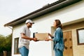 Courier Delivery. Man Delivering Package To Woman At Home Royalty Free Stock Photo