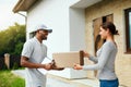 Courier Delivery. Man Delivering Package To Woman At Home Royalty Free Stock Photo
