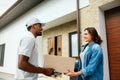 Courier Delivery. Man Delivering Package To Woman At Home Royalty Free Stock Photo