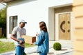 Courier Delivery. Man Delivering Package To Woman At Home Royalty Free Stock Photo