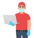 Courier or delivery person in mask and gloves showing laptop computer. Man holding PC. Corona virus epidemic outbreak. Online