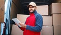 Courier with digital tablet delivering package. Mailman in front the van Royalty Free Stock Photo