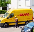 Courier enters DHL yellow delivery van after delivering the on time delivering package parcel Royalty Free Stock Photo