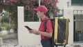 Courier girl with isothermal backpack consulting tablet