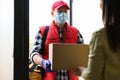 Courier giving cardboard box to woman. Delivery service during coronavirus quarantine Royalty Free Stock Photo