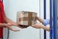 Courier giving damaged cardboard box to client. Poor quality delivery service Royalty Free Stock Photo