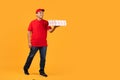 courier guy in uniform presents takeaway pizza boxes, yellow backdrop Royalty Free Stock Photo