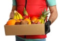 Courier holding box with assortment of exotic fruits on white background, closeup Royalty Free Stock Photo