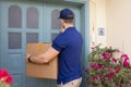 Courier holding sealed package and knocking on the door Royalty Free Stock Photo