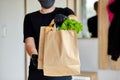 Courier man in black delivery box with food, contactless delivery