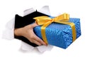 Courier man delivering or giving gift through torn white paper background